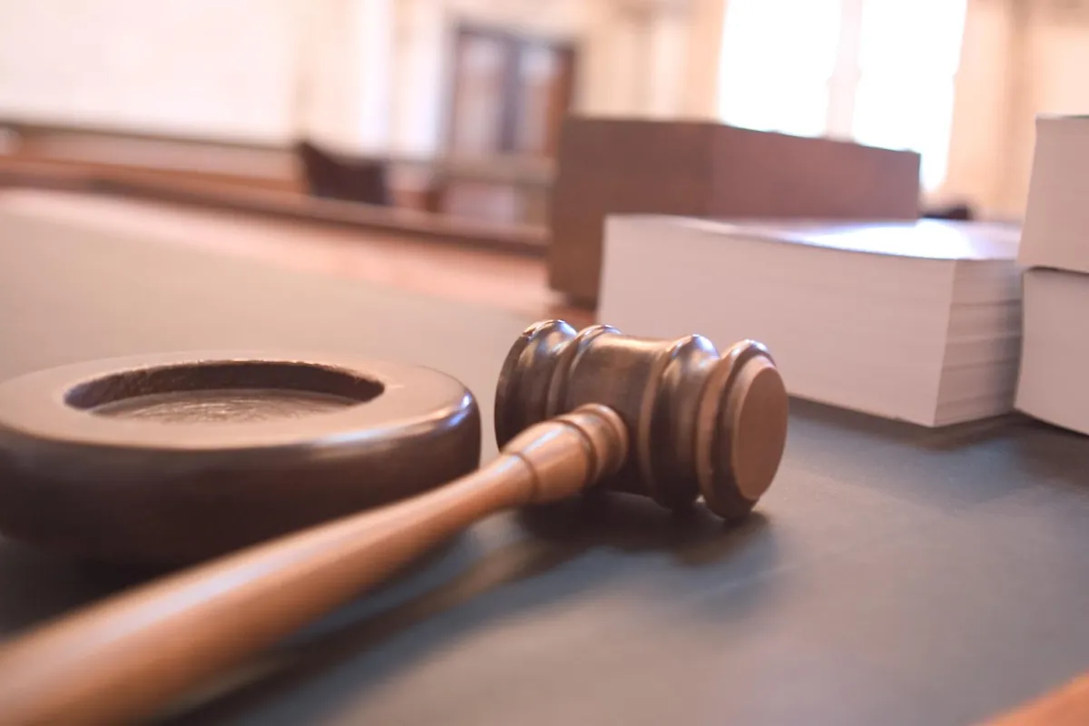 A judge's gavel resting beside law books in a courtroom
