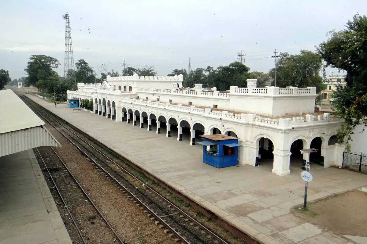 The white main building of Gujranwala railway station beside the tracks