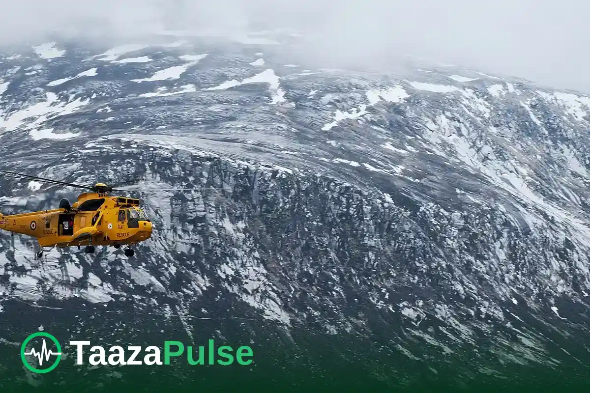 A yellow rescue helicopter flying over snowy mountains