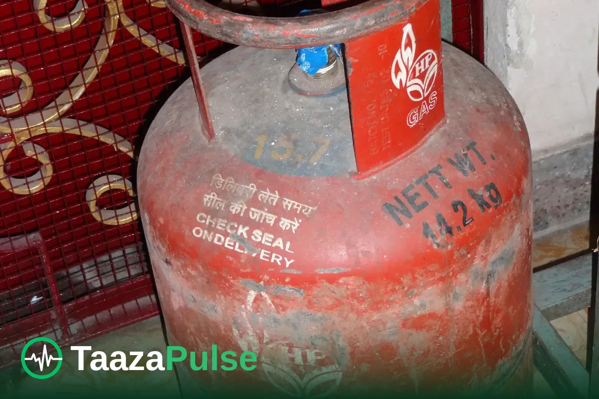 A red domestic LPG cylinder standing by a doorway