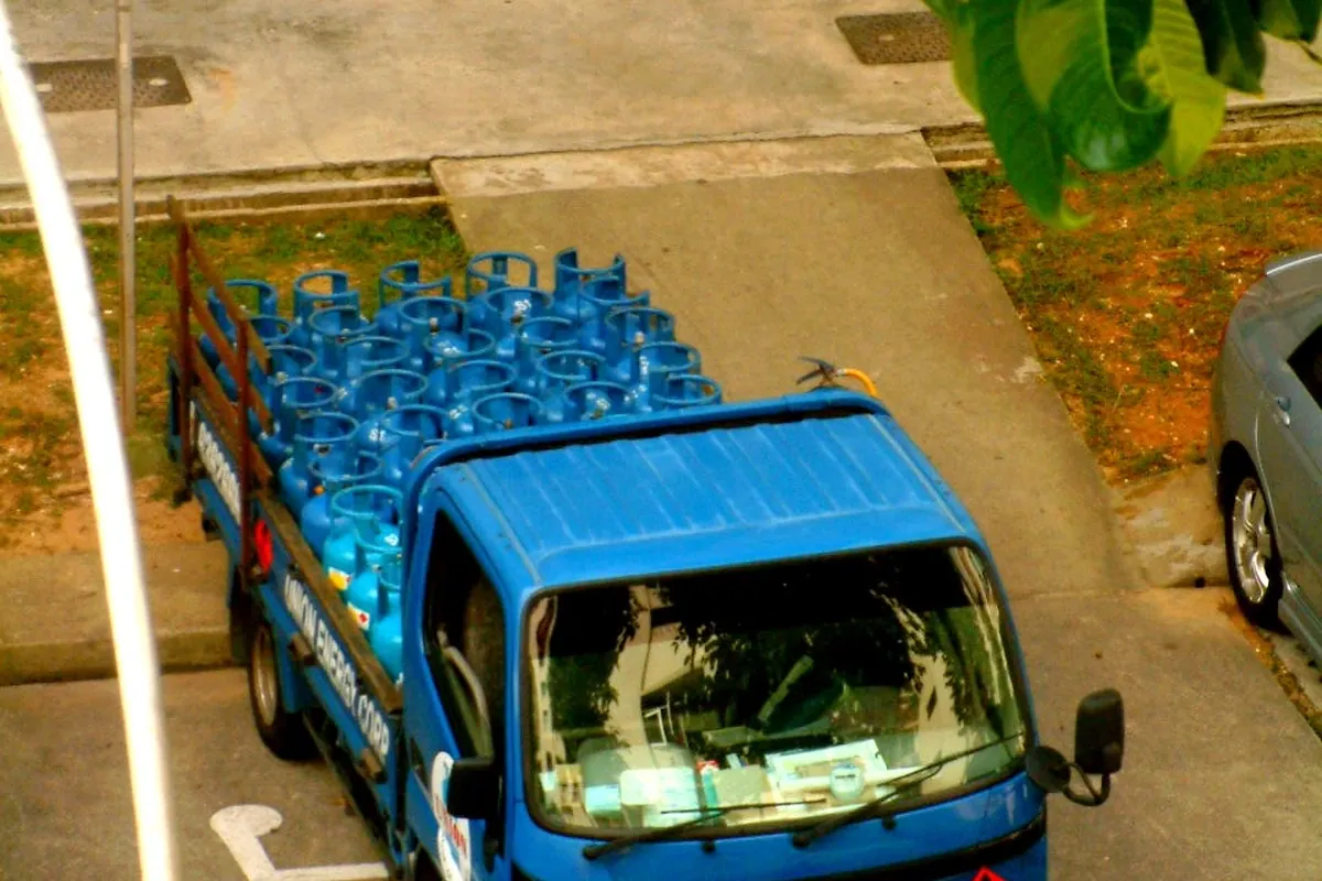 A delivery truck loaded with blue LPG cylinders
