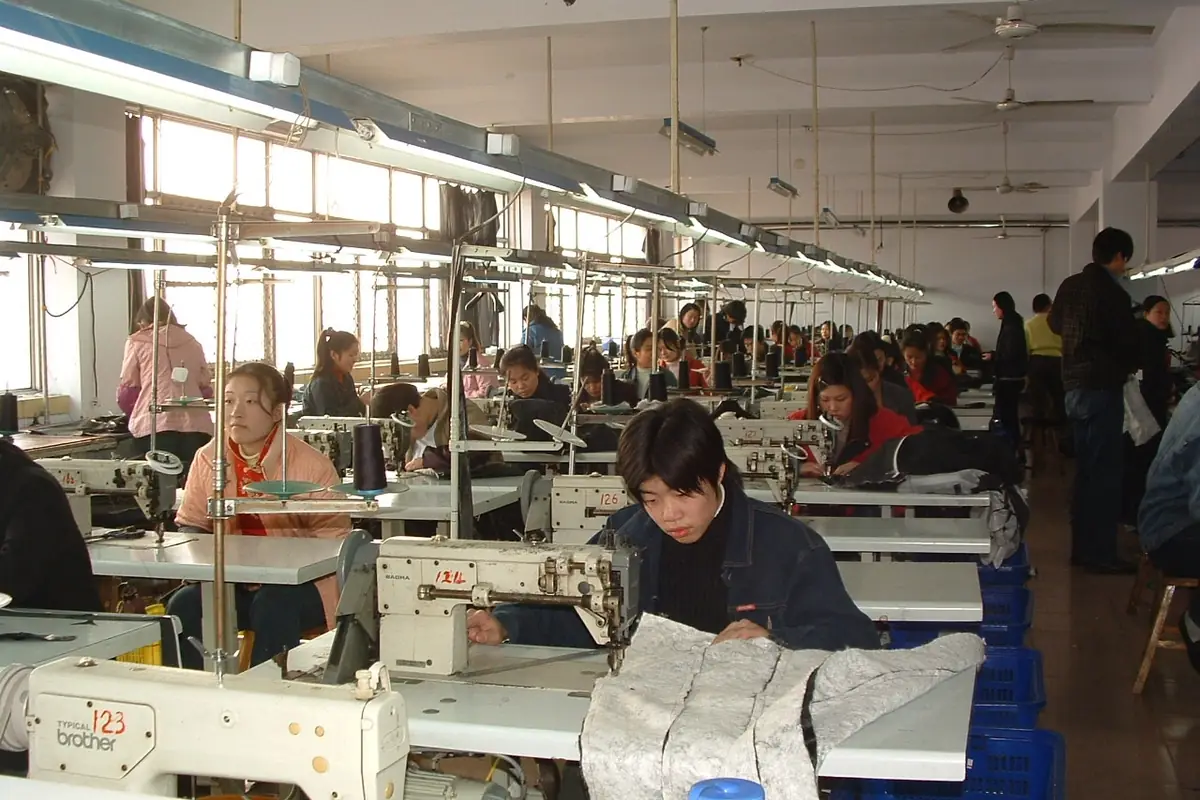 Garment workers at sewing machines in a factory