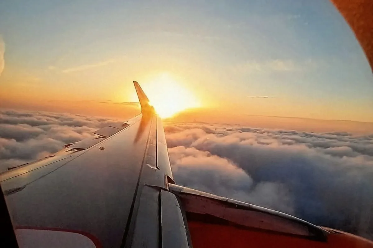 Sunset view from an airplane window above the clouds