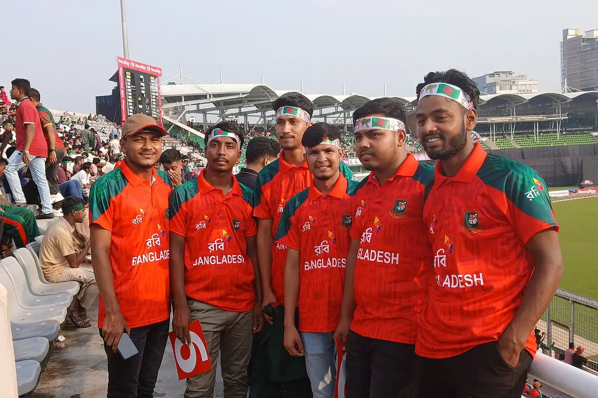 Spectators in a cricket stadium stand during a match