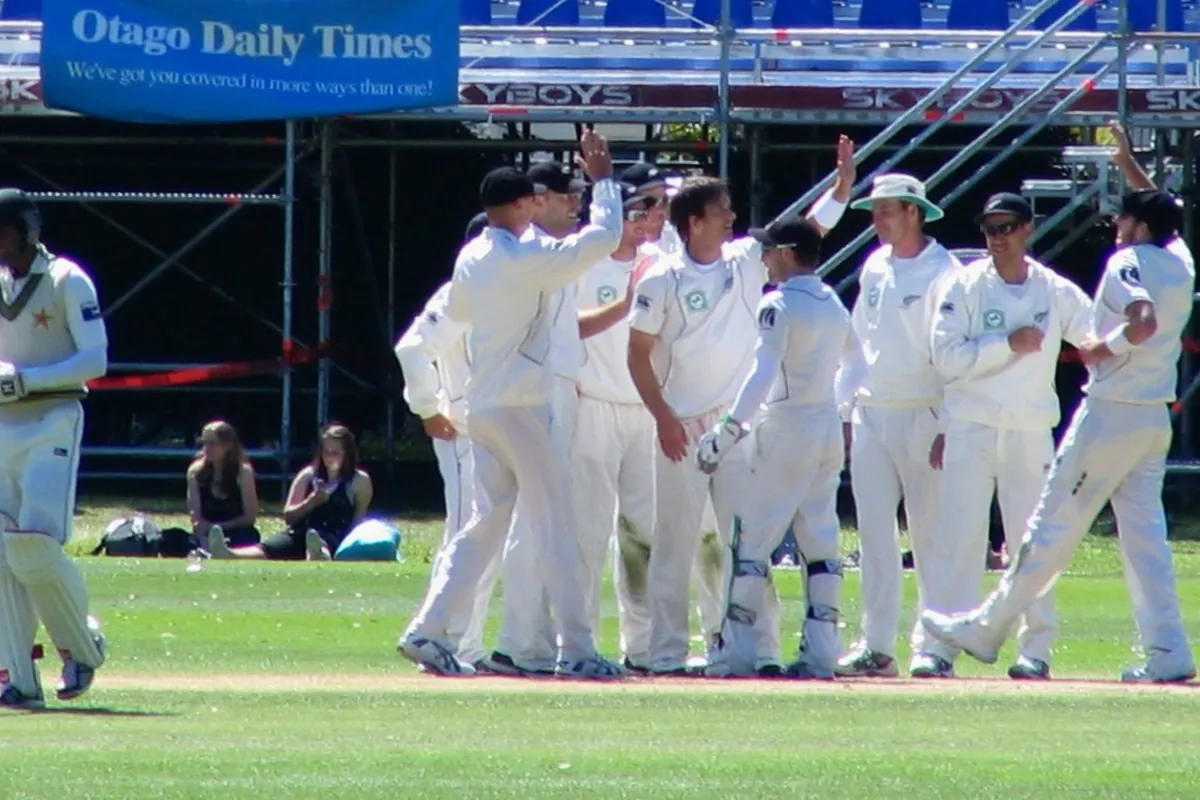 A Pakistan batter walks off as New Zealand players celebrate a wicket