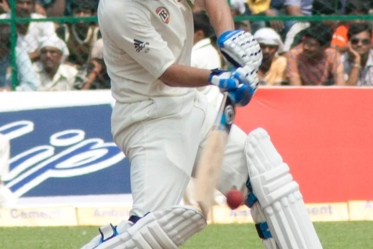 An Australian batsman plays a shot in front of a crowd