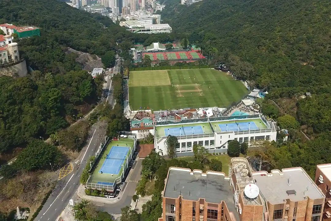 Aerial view of a cricket ground in Hong Kong surrounded by hills