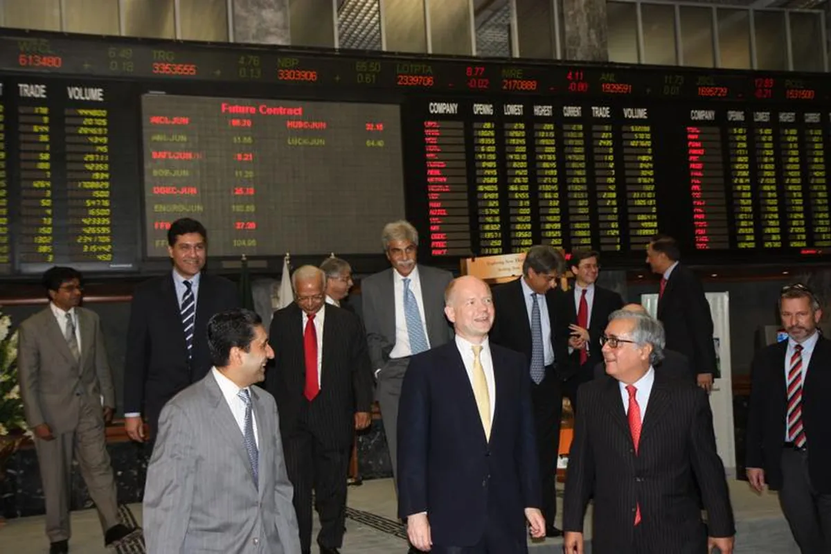 Trading floor at the Karachi Stock Exchange with share-price boards behind brokers